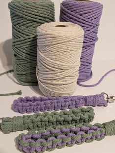 three spools of twine are next to some crocheted yarn on a table