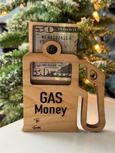 a wooden money holder with gas money in it