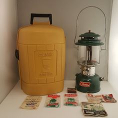 a yellow and green lantern sitting on top of a white counter next to a bottle