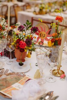 the table is set with flowers and place settings