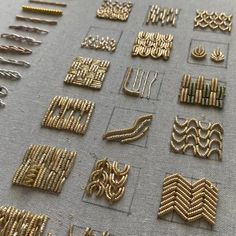 many different types and sizes of beading on a table with gold colored metal wire