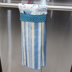 a dish towel hanging on the side of a refrigerator