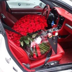 a bunch of roses sitting in the back seat of a car with its door open