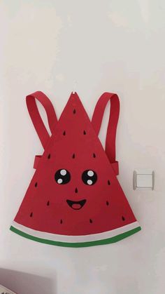 a watermelon shaped wall hanging in the shape of a triangle with eyes and ears