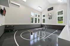 an indoor basketball court is shown in the middle of a room with high ceilings and large windows