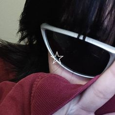 a close up of a person wearing sunglasses with a star pin in the middle of their eye