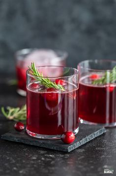 two glasses filled with cranberry punch and garnished with rosemary