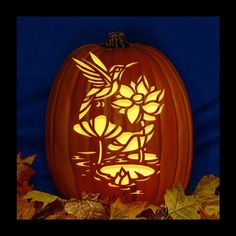 a carved pumpkin with an image of a bird on it's face and leaves around it