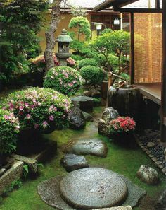 an image of a japanese garden with rocks and flowers in the foreground, surrounded by plants