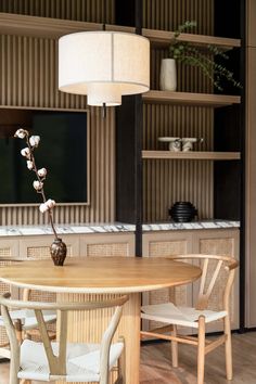 a wooden table with chairs around it and a vase with flowers on the table top