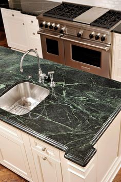 a kitchen with marble counter tops and stainless steel appliances