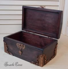 an old wooden box with ornate carvings on the lid and sides is shown in front of a white wall