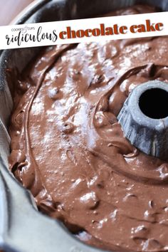 a cake pan filled with chocolate frosting and a wooden spoon