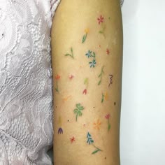 a close up of a person's arm with tattoos on it and flowers all over