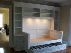 an empty room with built in bookshelves and drawers on the bottom shelf,