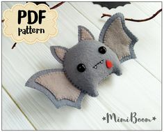 a felt bat hanging on the side of a white wooden wall with bats around it