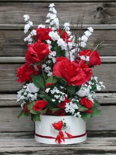 a white bucket with red and white flowers in it