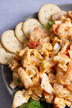 a plate with crackers and pasta salad on it, next to some crackers