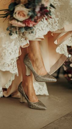 the bride's shoes are all covered in lace and sequins as she sits on her wedding day