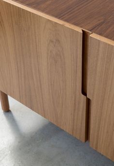 a close up of a wooden cabinet with two doors and one drawer on the side