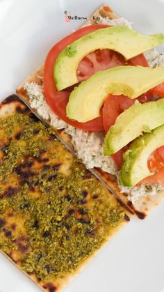 an enchilada with tomatoes, avocado and rice on a white plate