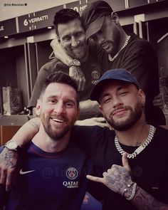 two men posing for the camera in front of a wall with tattoos on it and one pointing at the camera