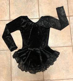 "This custom made, long-sleeved dress is made of a black VELVET with the sleeves and ruffled hem made of a black confetti dot, sequined material. Has a high neckline with lower back. The skirt is gathered at the waist and attached underneath is the matching brief. Measurements: SIZE BUST WAIST HIPS GIRTH 4-6 20-21\" 19-20\" 22-23\" 37-38\" 6x-7 22-23\" 20-21\" 23-25\" 41-42\" 8-10 24-25\" 21-22\" 25-27\" 44-45\" 12-14 26\" 22-23\" 27-29\" 46-48\"" Costume Dresses With Sequins For Party Season, Costume Sequin Dresses For Party Season, Long Sleeve Dresses For Costume Party, Black Sequin Stretch Dress, Black Costume Dress For Winter, Long Sleeve Dresses For Costume Party Season, Winter Costume Dress With Long Sleeves, Winter Costume Long Sleeve Dress, Long Sleeve Fall Costume Dress