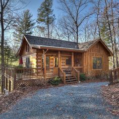 a cabin in the woods with stairs leading up to it's front door and covered porch