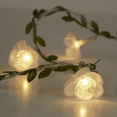 some lights that are on top of a white table and one has a flower in the middle