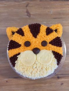 a cake shaped like a tiger head on top of a wooden table