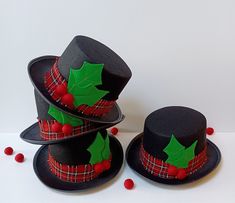 three hats with holly leaves and red berries on the brimmed hat are sitting next to each other