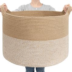 a person holding a large woven basket in front of their face, with both hands on the handle