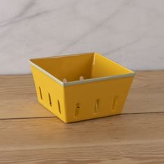 a yellow container sitting on top of a wooden table