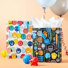 two gift bags and balloons on a table