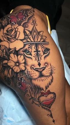 a woman with a tattoo on her thigh and arm, has a tiger surrounded by flowers