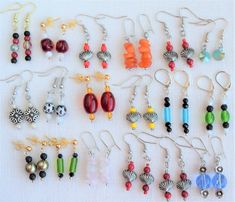 a collection of earrings are displayed on a white surface, including beads and seashells