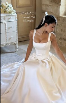 a woman in a wedding dress sitting on the floor