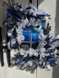 a blue and white wreath hanging on the side of a door