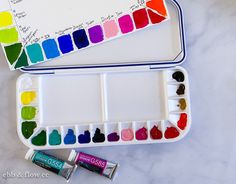 an artist's palette with watercolors and markers