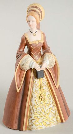 a figurine of a woman wearing a dress and hat