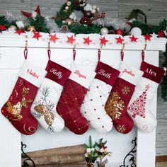 christmas stockings hanging from a mantel decorated with red and gold decorations