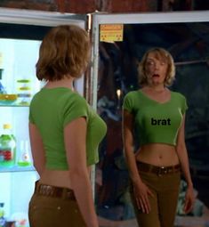 two women standing in front of a refrigerator with the word brat on it's shirt