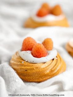 small desserts are topped with whipped cream and raspberries on top of each other