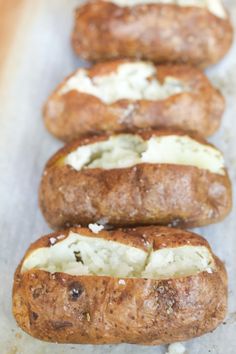 four bread rolls with cheese on them lined up