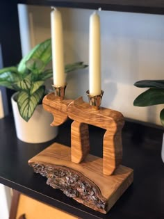 two candles sitting on top of a wooden block