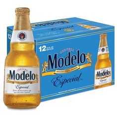 two bottles of modelo beer next to each other in front of a blue box