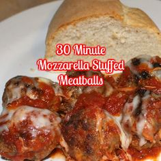 a white plate topped with meatballs covered in sauce next to a loaf of bread