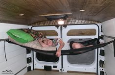 two children are sleeping in the back of a camper with their backs to each other