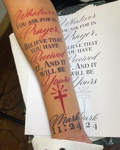 a person with a cross on their arm and some writing on the back of his arm