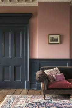 a living room filled with furniture and pink walls